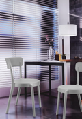 Alt text: BREACH.PNG	White Breach armless cafe chairs at a dining table