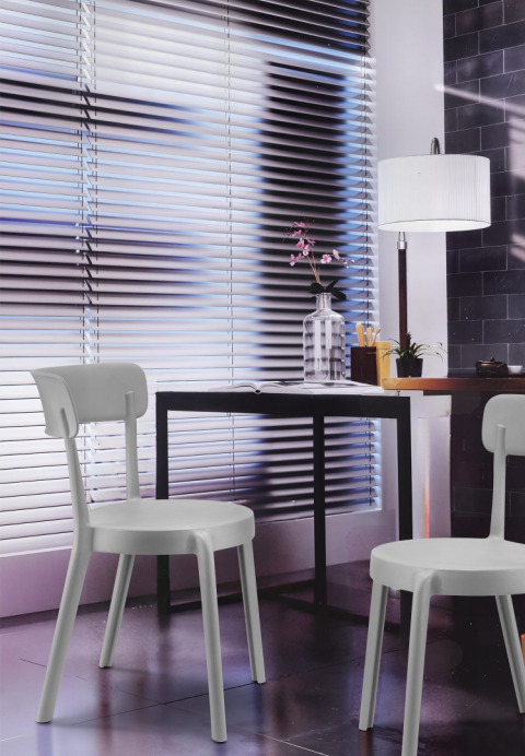 Alt text: BREACH.PNG	White Breach armless cafe chairs at a dining table