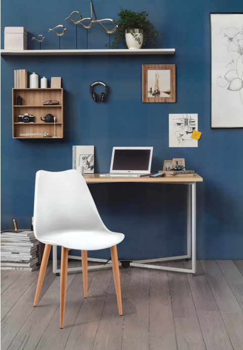 Alt text: CLASSIC.PNG	White Classic shell cafe chair with wooden finish legs at a desk